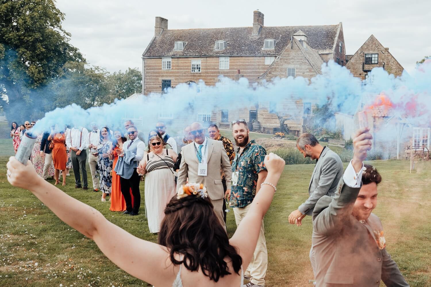 Molecey Mill Wedding photographer, a photo of bride and groom with smoke bombs