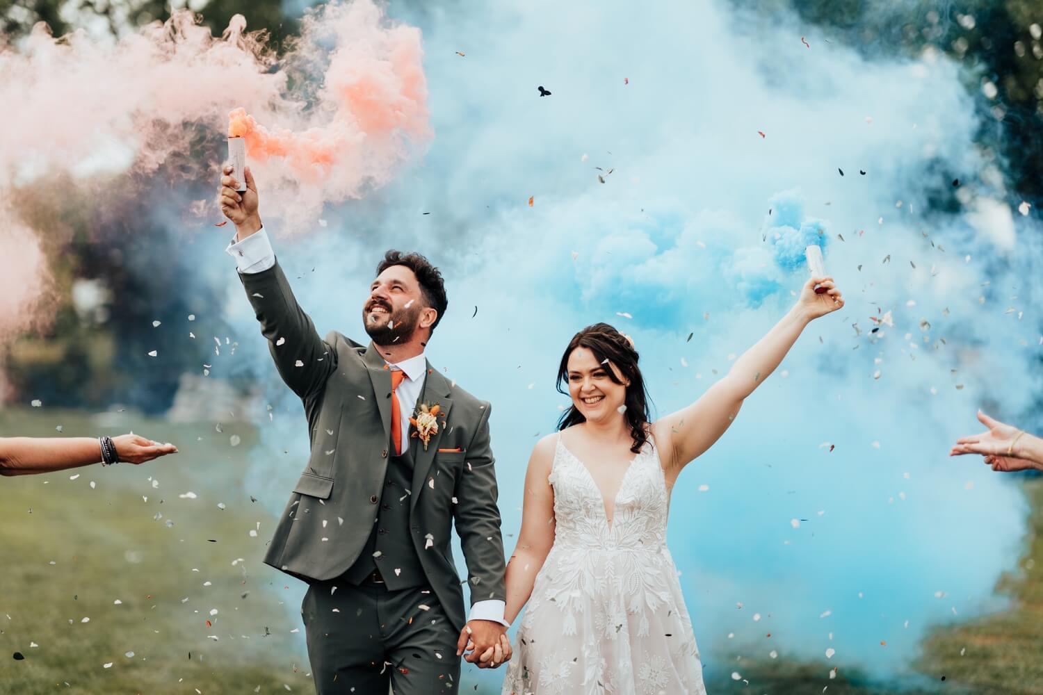Molecey Mill Wedding photographer, a photo of bride and groom with smoke bombs