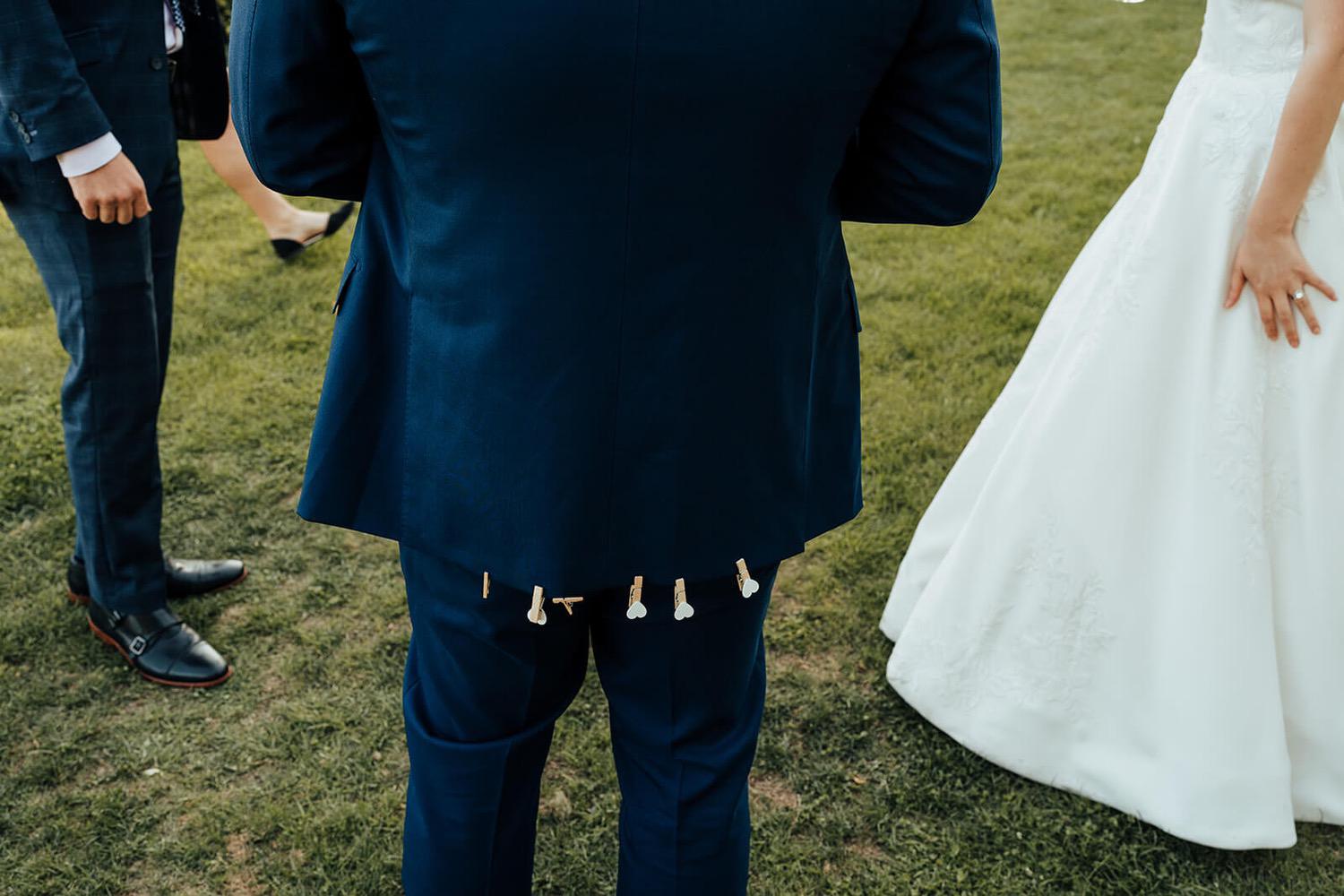 Bride placing a peg on the grooms suit