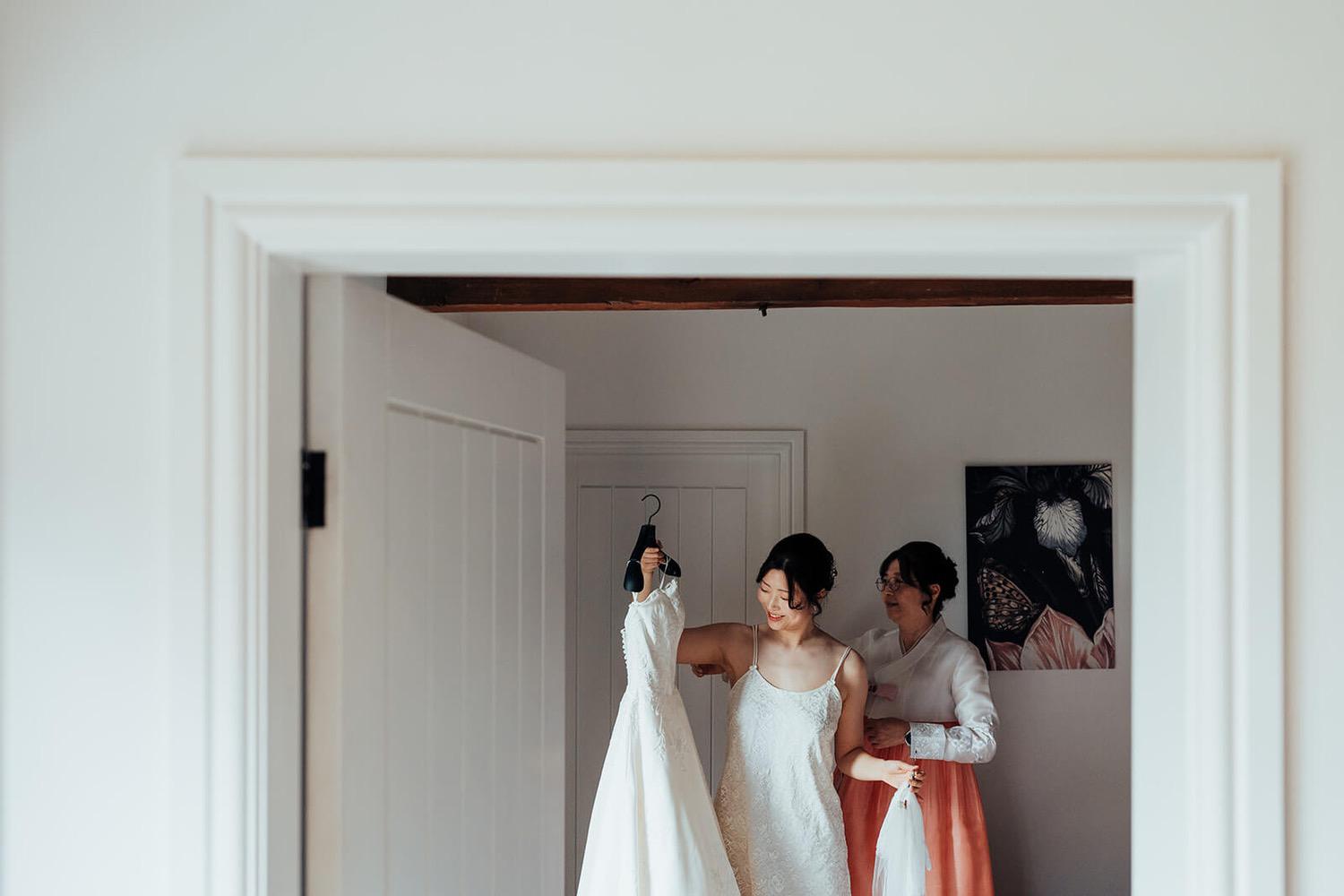 Bride getting her dress ready for her wedding at Pheasantry Brewery